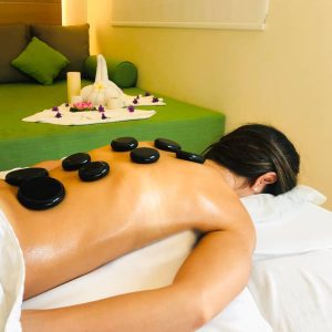 a man lying on spa deck getting relaxation stone therapy